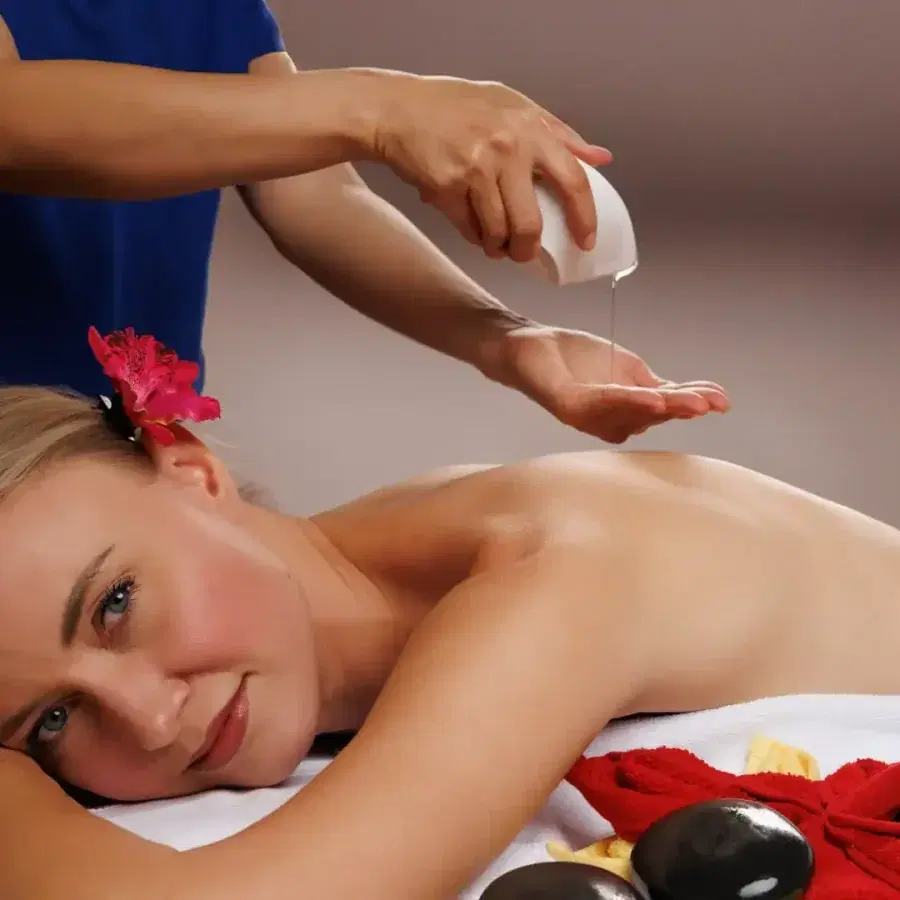 Warm massage oil being poured onto a client's back during a therapeutic massage session