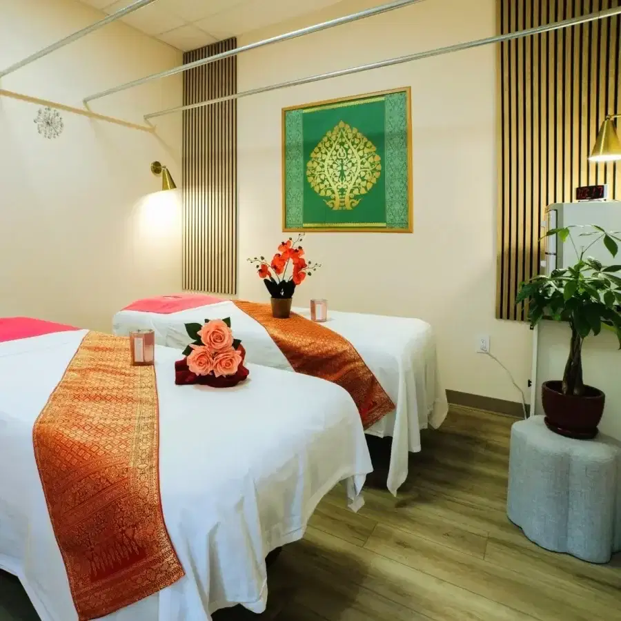 A private couples massage room at Blue Diamond Thai Spa & Massage featuring two decorated beds and traditional Thai art